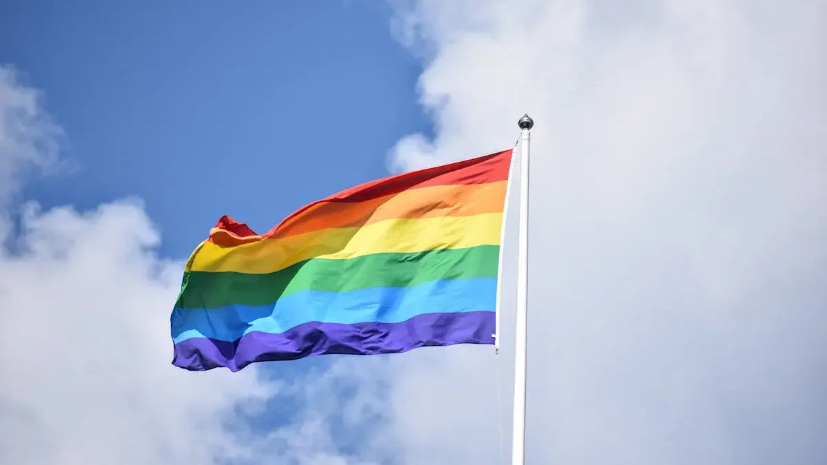 a rainbow flag flying high in the sky