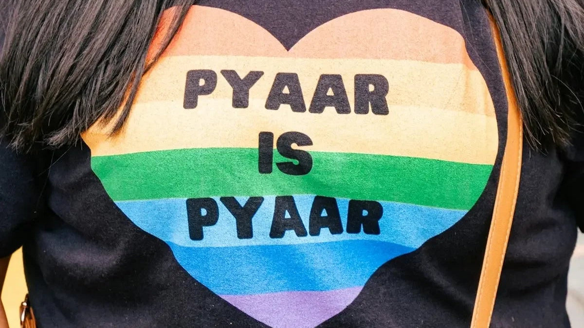 a woman is wearing a gay pride shirt